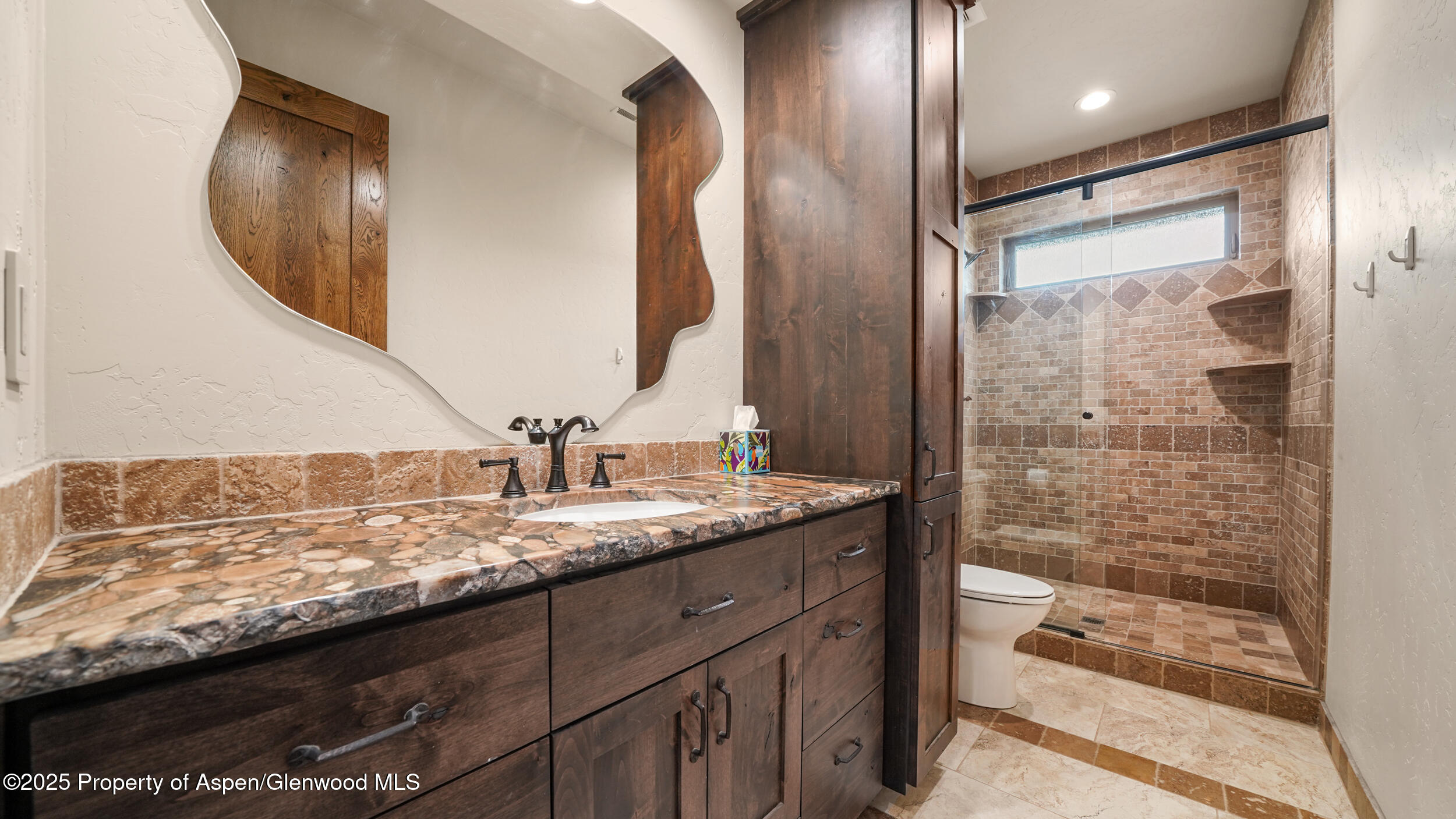 1980 Alabama Boy Court Fruita, CO 81521 - Photo 29 of 52 a bathroom with a granite countertop sink a mirror and shower