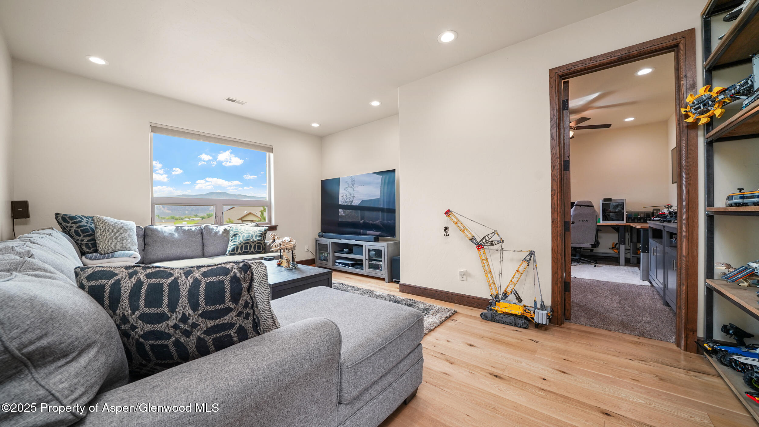 1980 Alabama Boy Court Fruita, CO 81521 - Photo 31 of 52 a living room with furniture a flat screen tv and a table