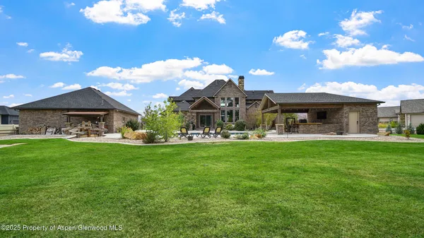 a view of a house with a big yard and sitting area