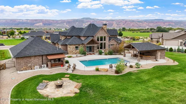 an aerial view of a house with swimming pool garden view and a large tree
