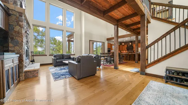 a living room with furniture a fireplace and a floor to ceiling window