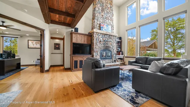 a living room with furniture a large window and a fireplace