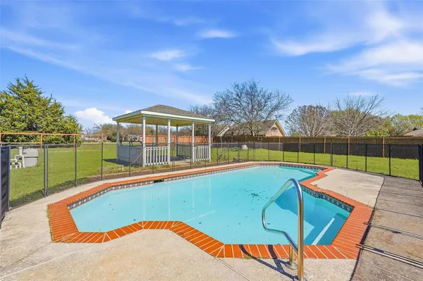 a view of a swimming pool with a yard and sitting area