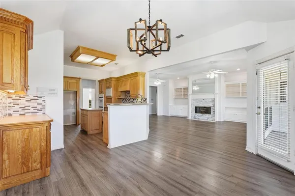 a view of a kitchen center island wooden floor and stainless steel appliances