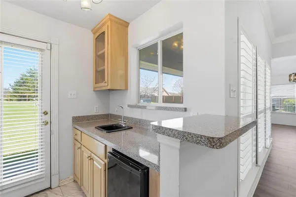 a kitchen with granite countertop a sink stove and cabinets
