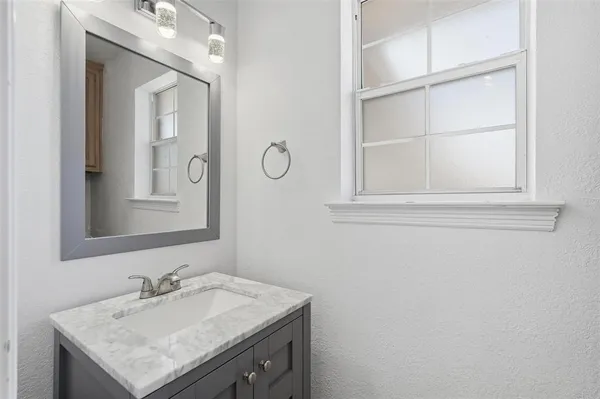 a bathroom with a sink vanity and a mirror