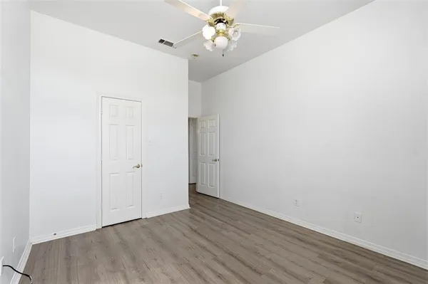 an empty room with a window and a ceiling fan