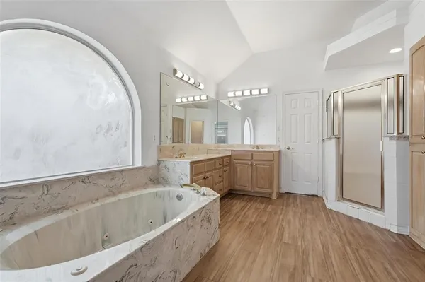 a bathroom with a tub a sink and a mirror