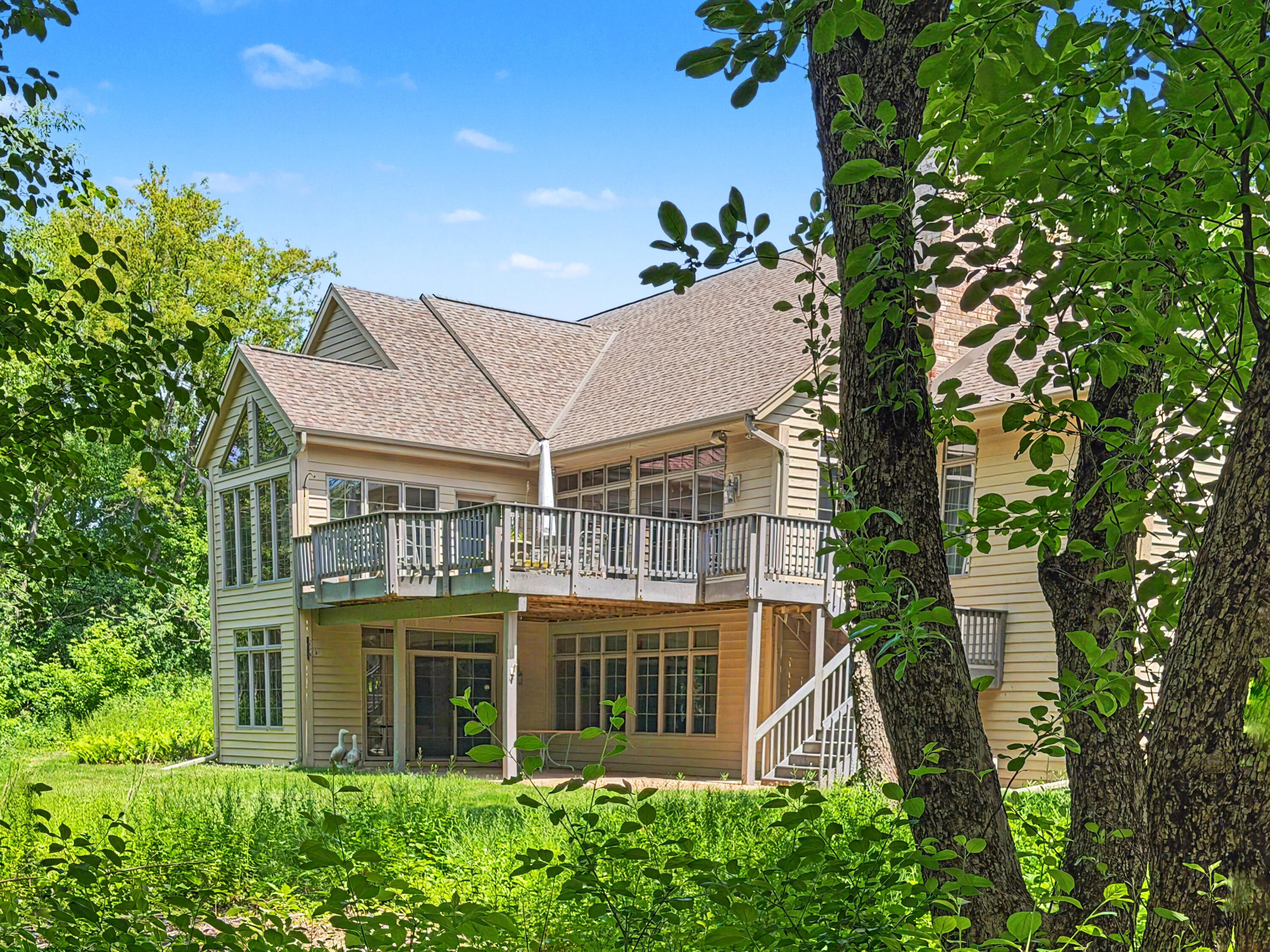 W291-s5245 Ridgefield Road Waukesha, WI 53189 - Photo 6 of 44 The walkout ranch offers exceptional privacy, expansive windows, a 32’ x 16’ composite deck, and covered patio overlooking the wooded 3-acre setting. (Enhanced Photo)