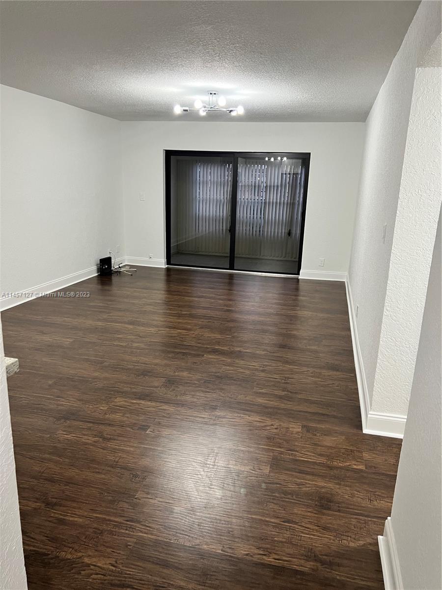 9355 Southwest 8th Street, Unit 124 Boca Raton, FL 33428 - Photo 4 of 23 an empty room with wooden floor and windows