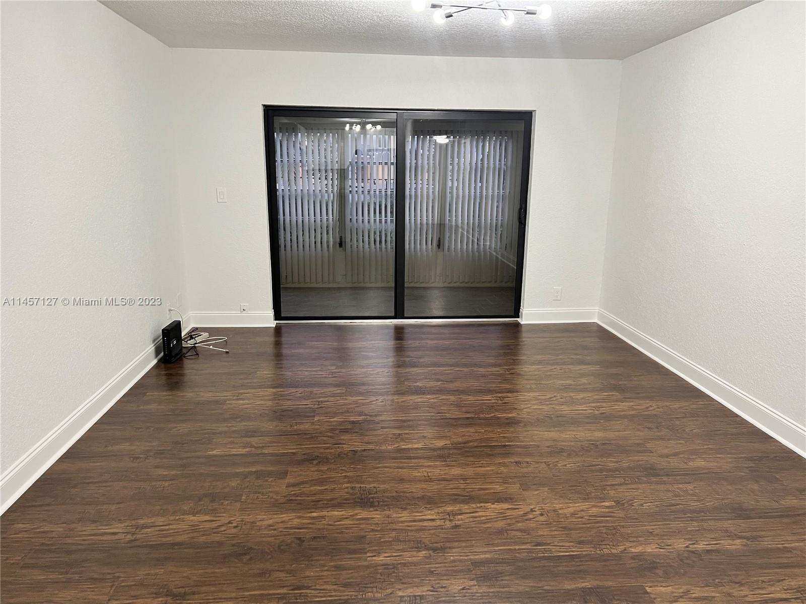 9355 Southwest 8th Street, Unit 124 Boca Raton, FL 33428 - Photo 7 of 23 a view of an empty room with wooden floor