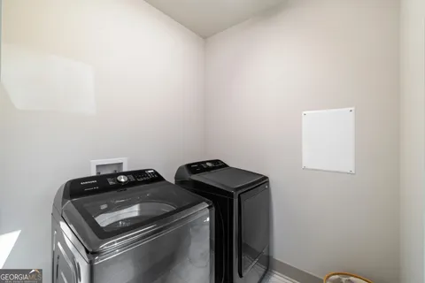 a view of an empty room and a kitchen with a stove