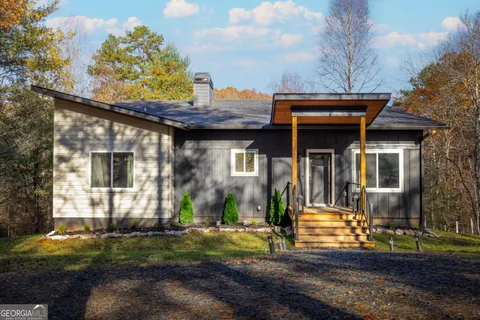 a front view of a house with a yard and trees