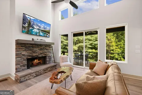 a living room with furniture a fireplace and a large window