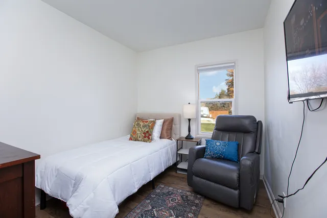 a bedroom with a bed couch and a window
