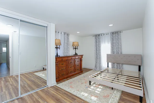 a bedroom with a bed and wooden floor