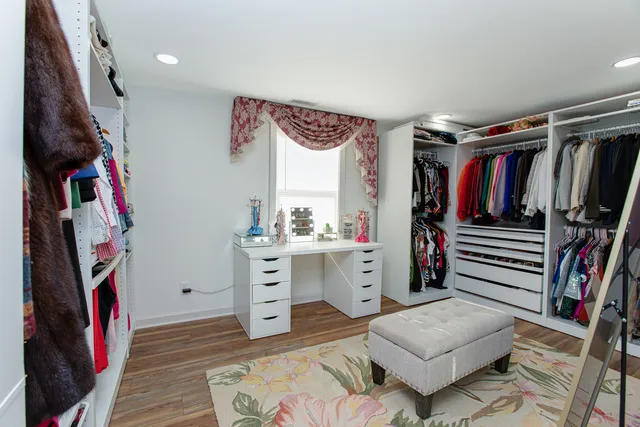 a view of walk in closet with clothes and shoes