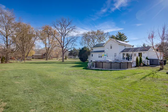 a view of a house with a big yard and large trees