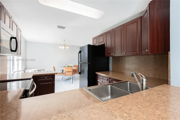 a dining room with furniture a chandelier and window