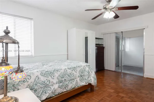 a bedroom with a bed chandelier and a window