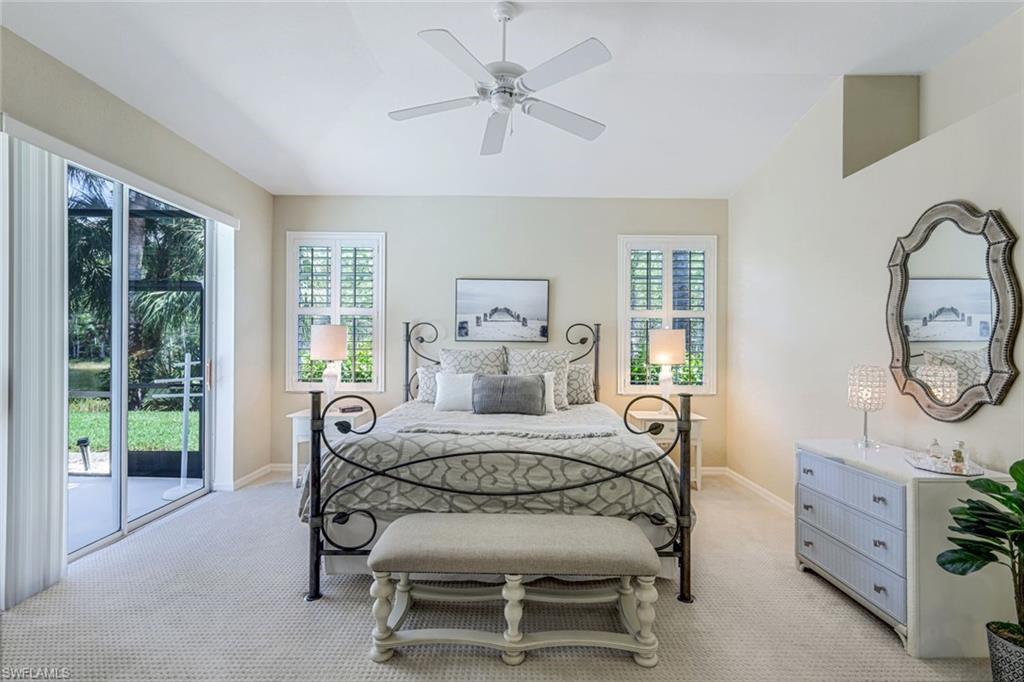 10215 Cape Roman Road, Unit 101 Estero, FL 34135 - Photo 13 of 50 a bedroom with a bed and a chandelier