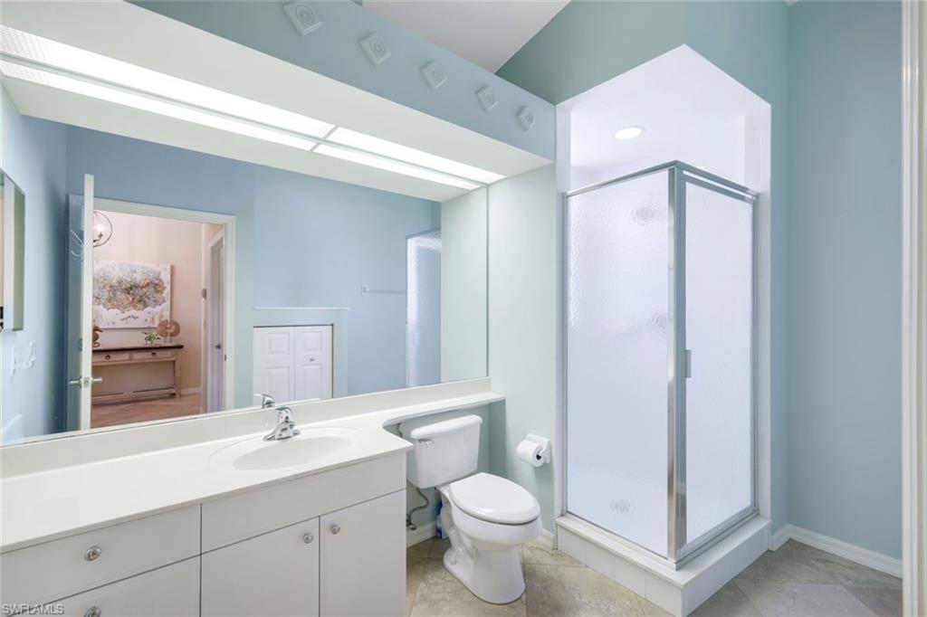 10215 Cape Roman Road, Unit 101 Estero, FL 34135 - Photo 17 of 50 a bathroom with a double vanity sink toilet and mirror