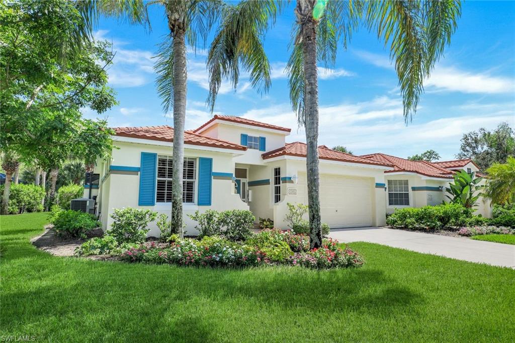 10215 Cape Roman Road, Unit 101 Estero, FL 34135 - Photo 3 of 50 a front view of a house with a garden
