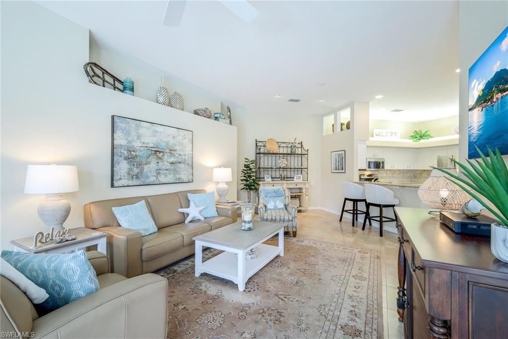 10215 Cape Roman Road, Unit 101 Estero, FL 34135 - Photo 6 of 50 a living room with furniture and a painting on the wall