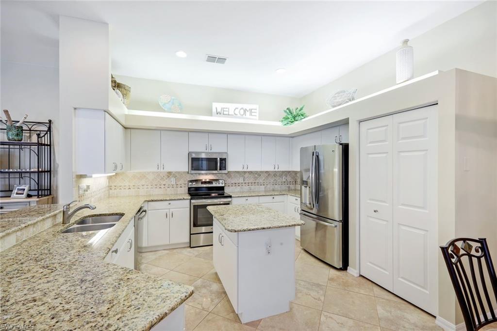 10215 Cape Roman Road, Unit 101 Estero, FL 34135 - Photo 10 of 50 a kitchen with stainless steel appliances granite countertop a refrigerator stove and sink
