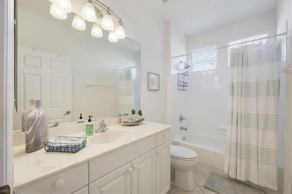 a bathroom with a granite countertop sink a toilet and shower