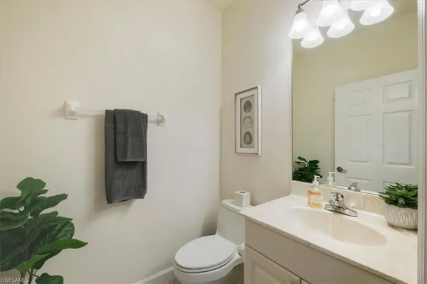 a bathroom with a sink vanity mirror and toilet