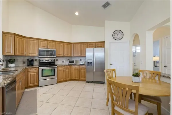 a kitchen with stainless steel appliances granite countertop a refrigerator a stove top oven a sink and dishwasher