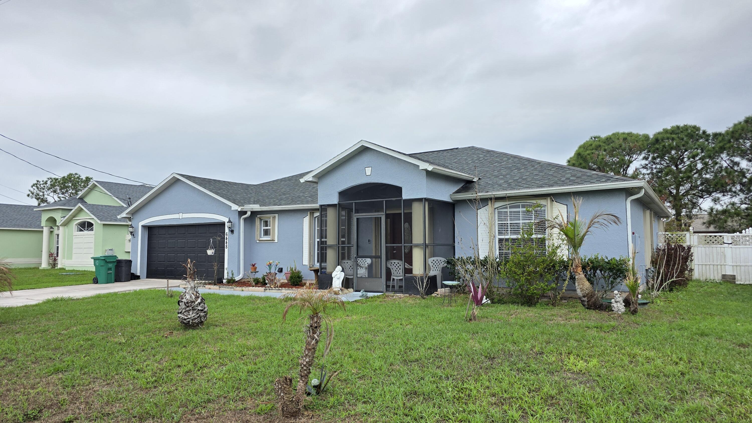 6448 Northwest Colgate Street Port St. Lucie, FL 34986 - Photo 1 of 21 a front view of house with yard and green space