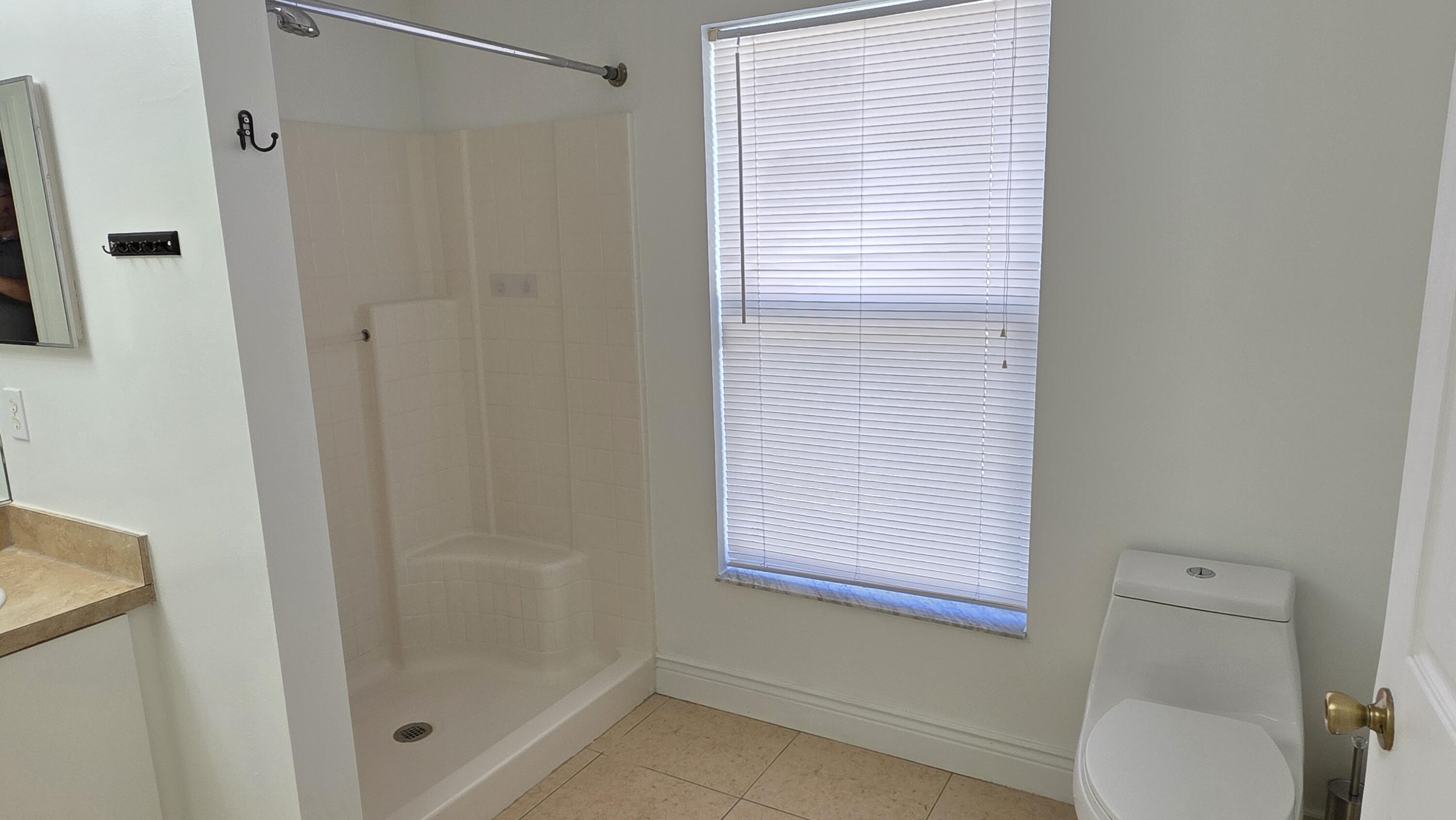 6448 Northwest Colgate Street Port St. Lucie, FL 34986 - Photo 14 of 21 a bathroom with a shower and a toilet