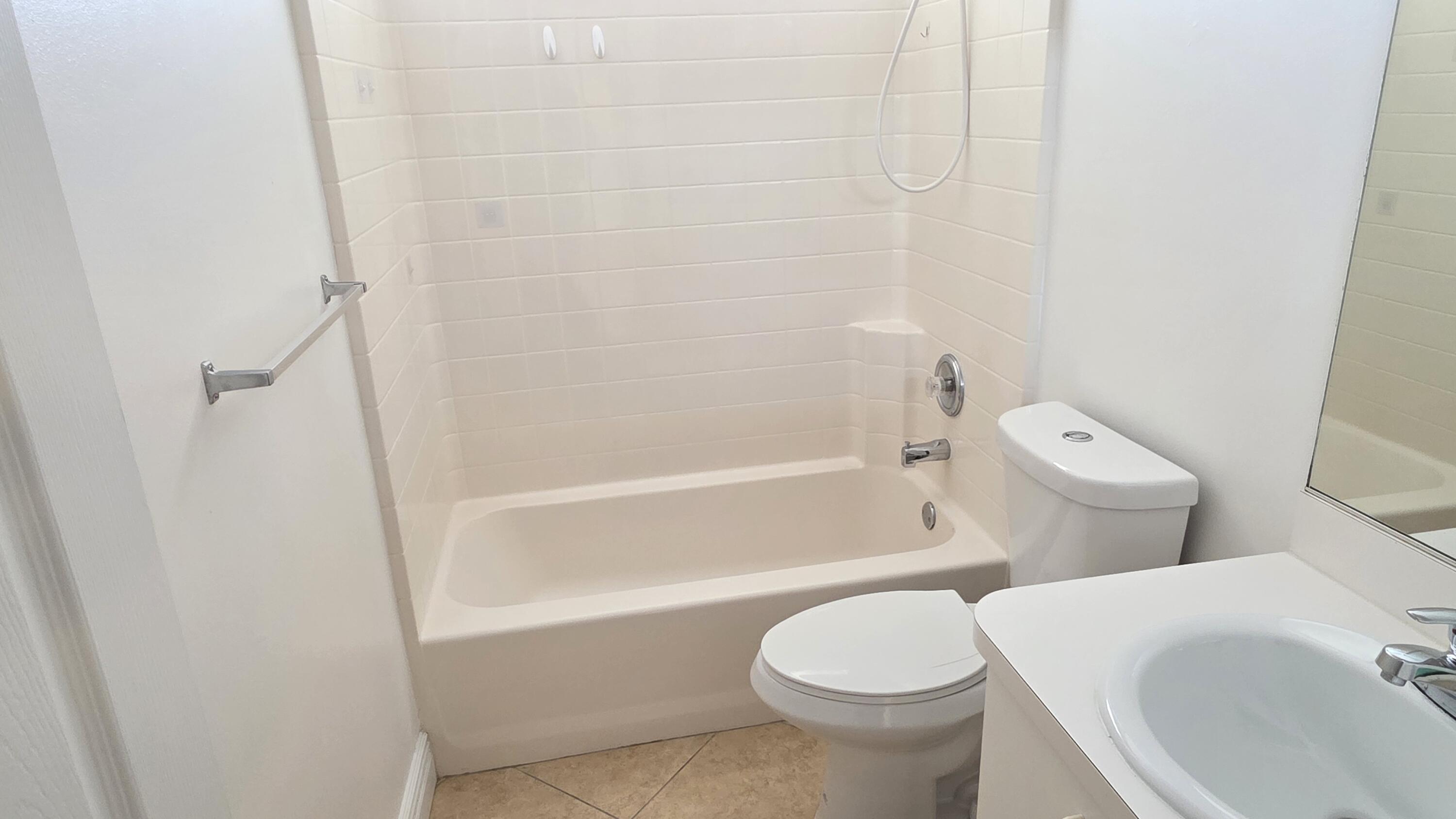 6448 Northwest Colgate Street Port St. Lucie, FL 34986 - Photo 17 of 21 a white toilet sitting next to a bath tub