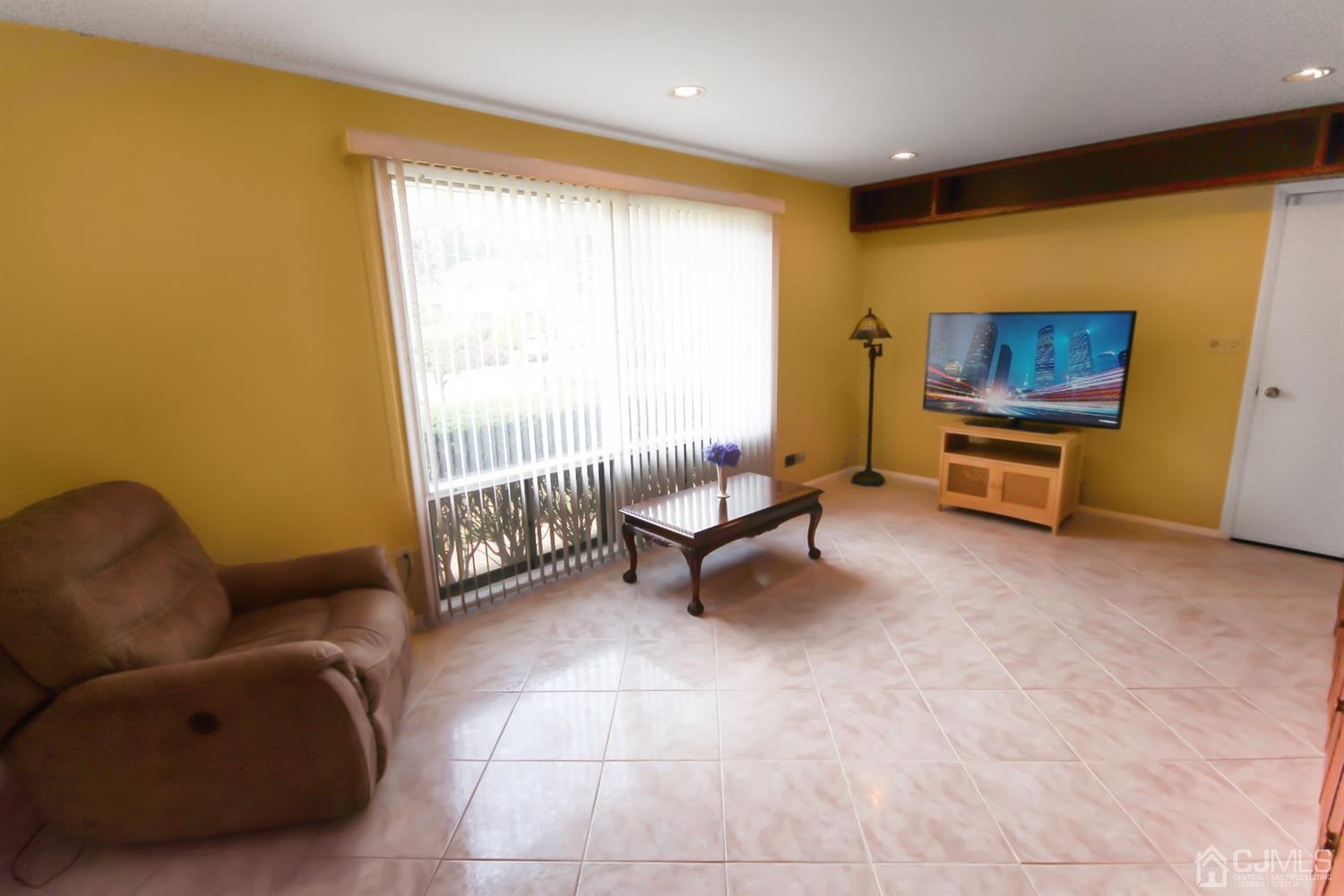 22 Bruning Road East Brunswick, NJ 08816 - Photo 28 of 31 a living room with furniture a rug and a projector
