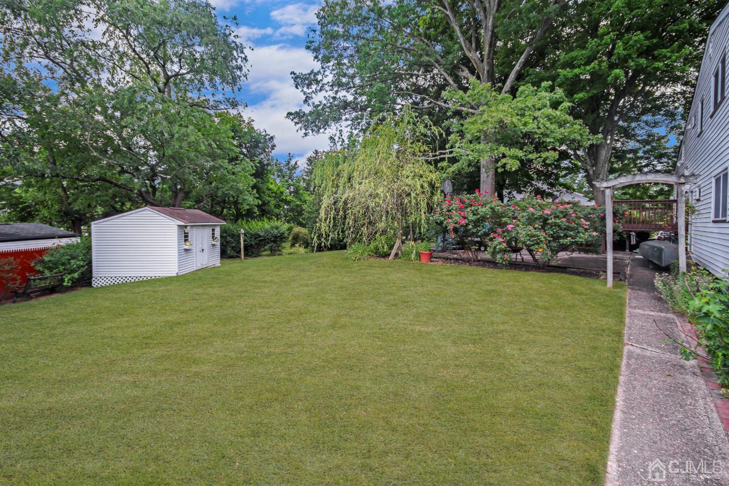 22 Bruning Road East Brunswick, NJ 08816 - Photo 6 of 31 a backyard of a house with plants and large trees