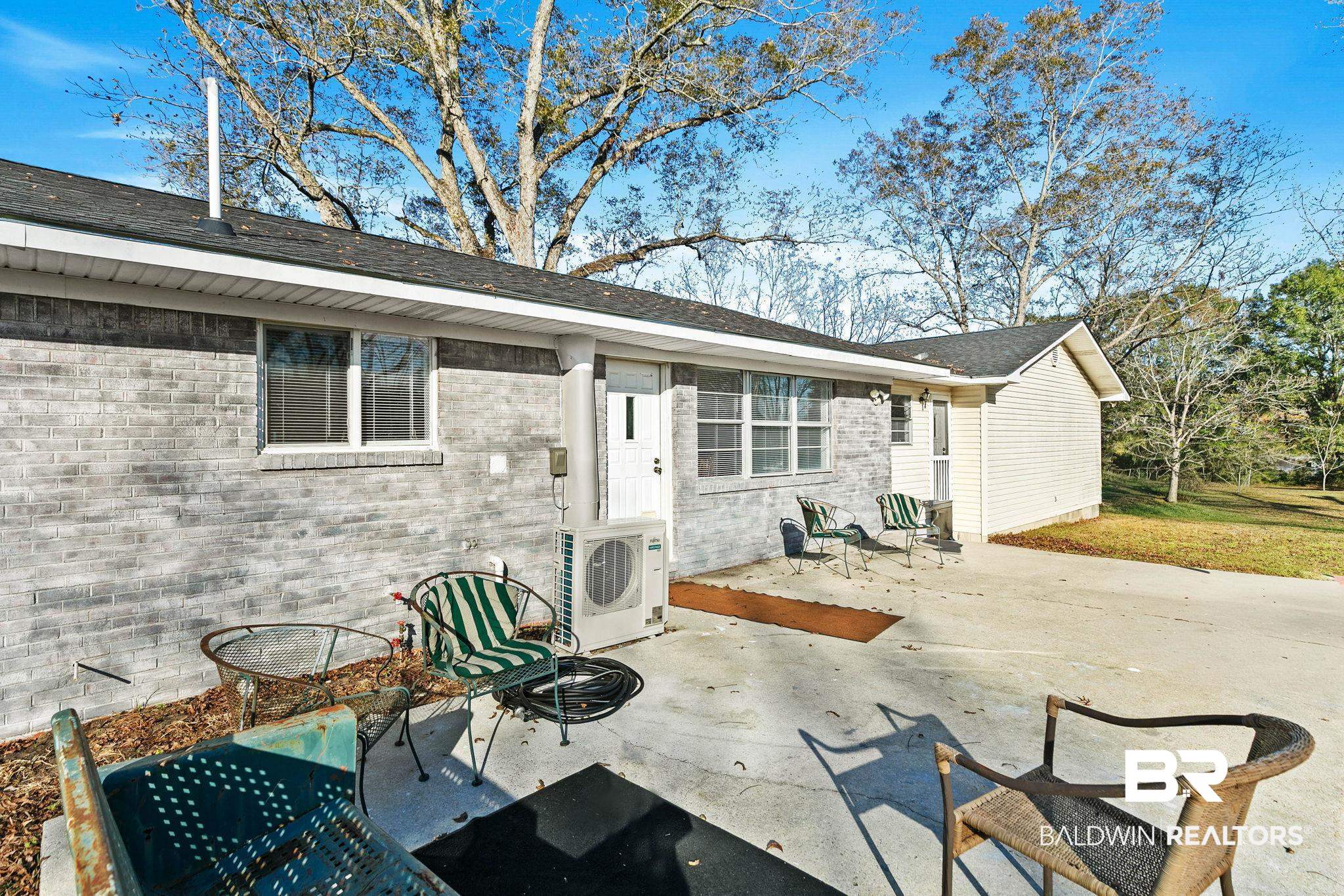 21267 Loop Road Andalusia, AL 36421 - Photo 57 of 72 Back of house featuring a patio, brick siding, and roof with shingles