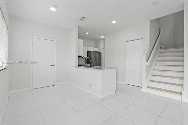 a view of kitchen with cabinets and refrigerator