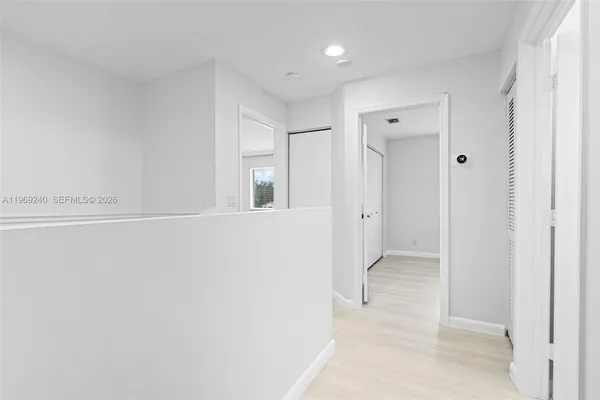 an empty room with wooden floor and window