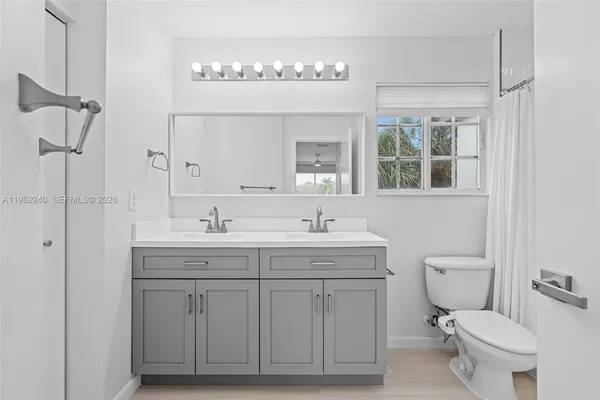 a bathroom with a granite countertop toilet a sink and shower