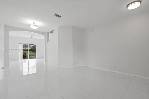 a view of an empty room with wooden floor and windows