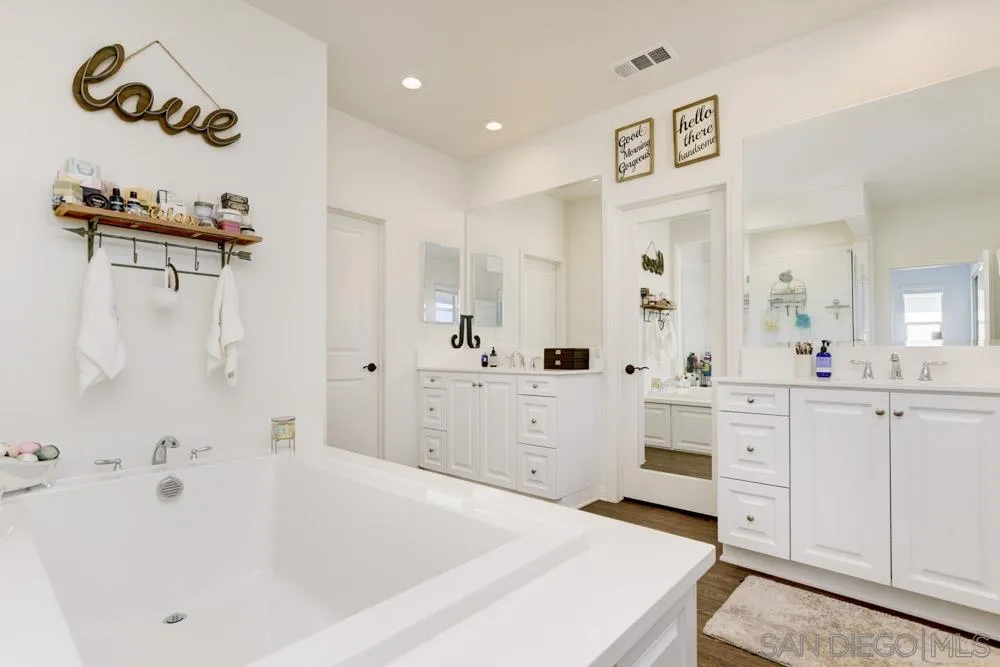 3684 Tavara Circle San Diego, CA 92117 - Photo 18 of 22 a spacious bathroom with a bathtub sink and mirror