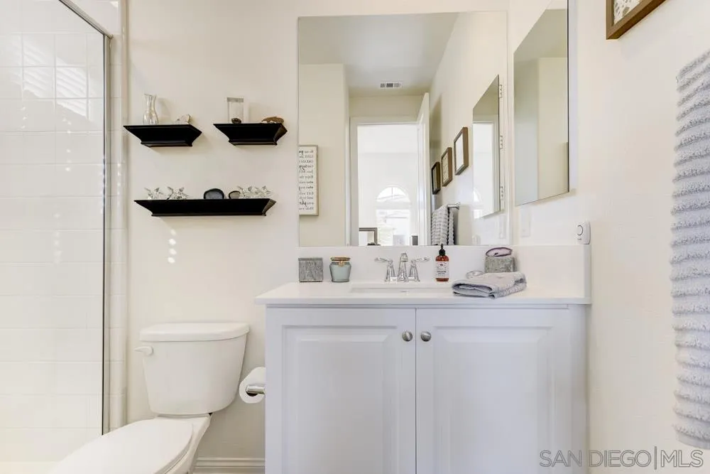 3684 Tavara Circle San Diego, CA 92117 - Photo 9 of 22 a bathroom with a sink a toilet and a mirror