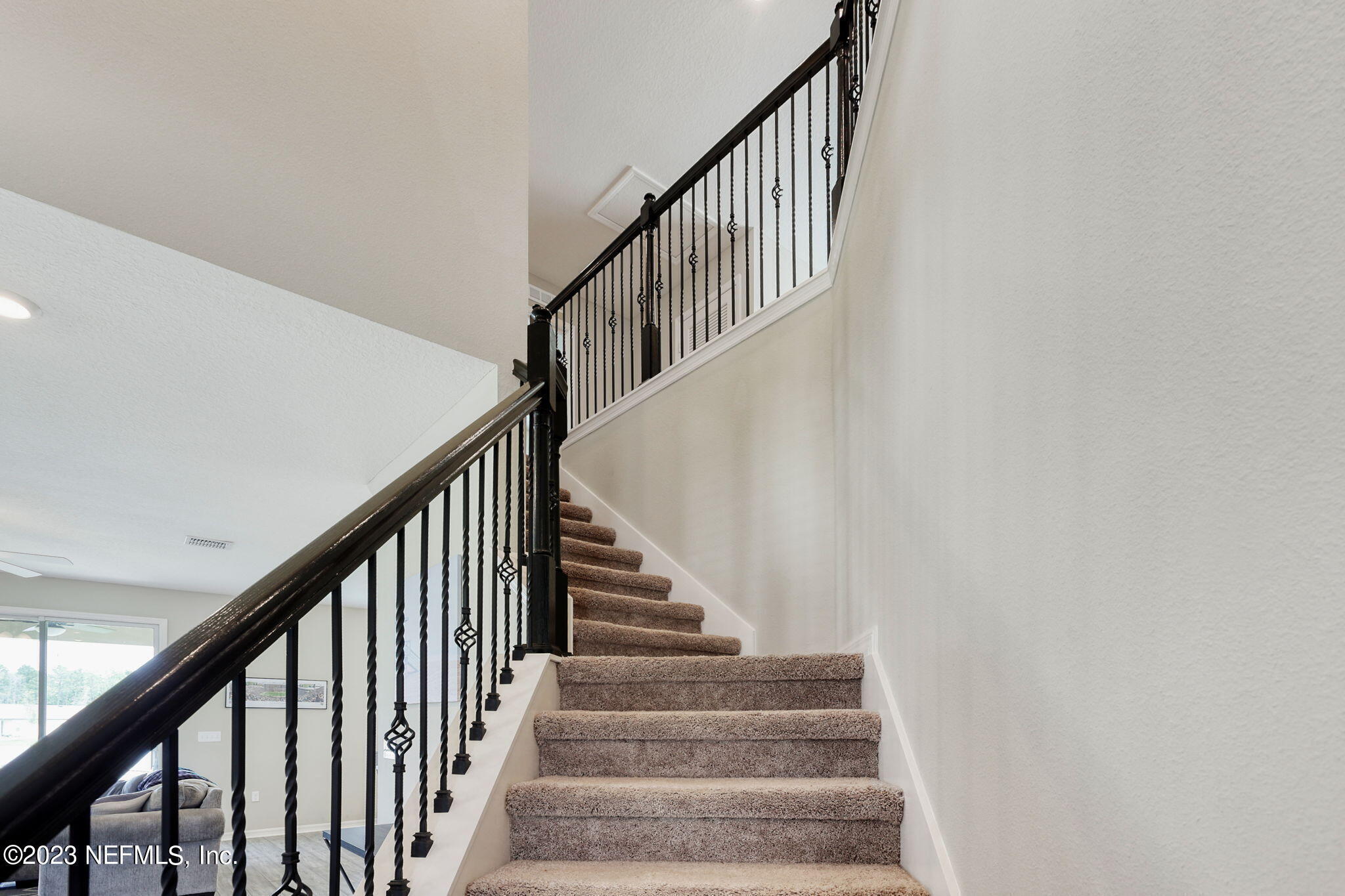 427 Falcon Ridge Road St. Augustine, FL 32084 - Photo 21 of 45 a view of staircase with lots of frames on wall and wooden floor
