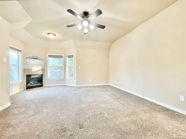 an empty room with fan and windows