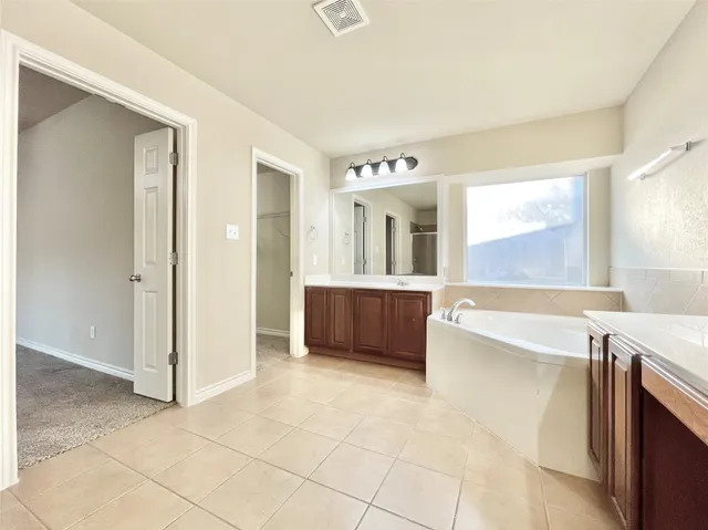 a large bathroom with a tub and shower