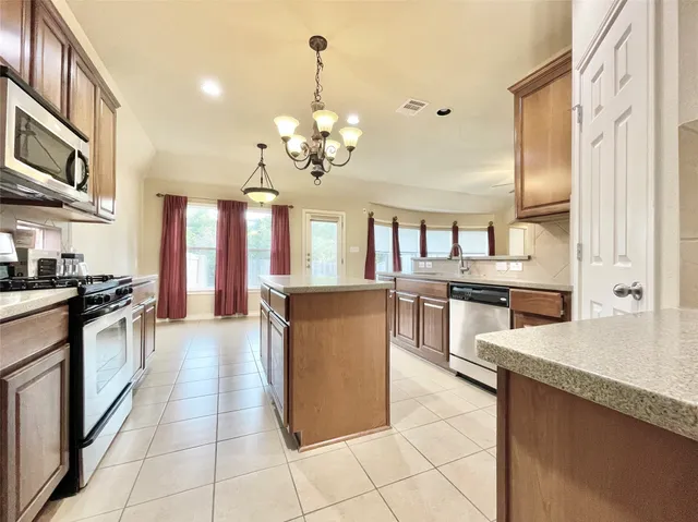 a large kitchen with stainless steel appliances granite countertop a stove and a refrigerator