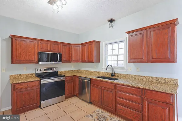 a kitchen with stainless steel appliances granite countertop a refrigerator stove and sink