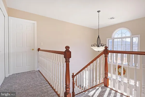 a bedroom with a bed chandelier and a window